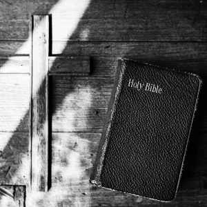 Cross and Holy Leather Bible on Wooden Background