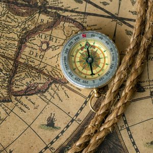 Old compass on vintage map with rope